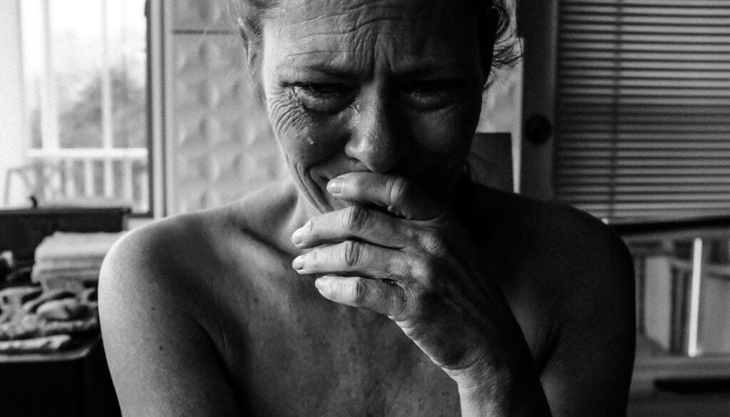 close up photography of crying woman next inside room